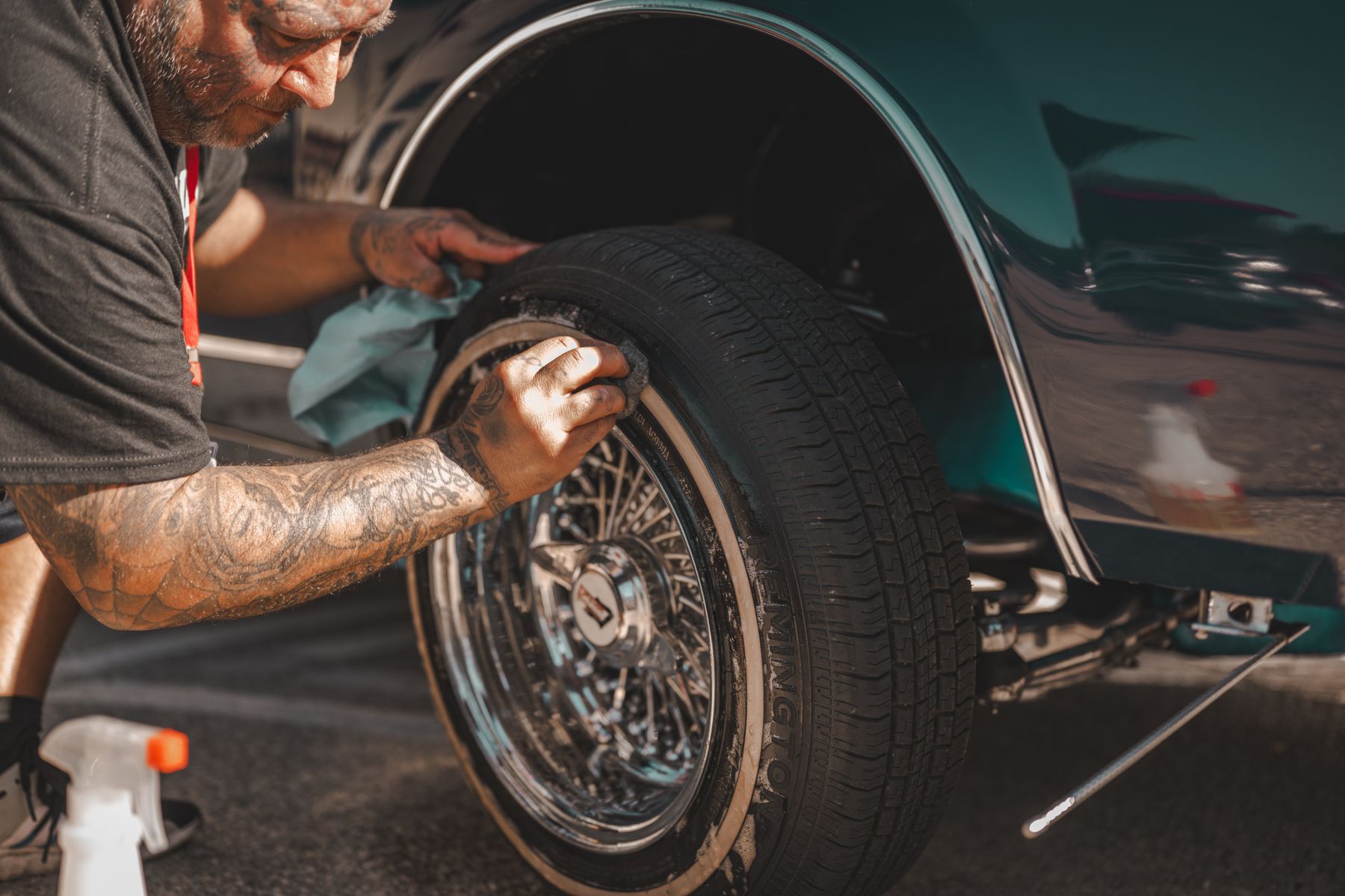 A vehicle wheel being cleaned with detailing tools